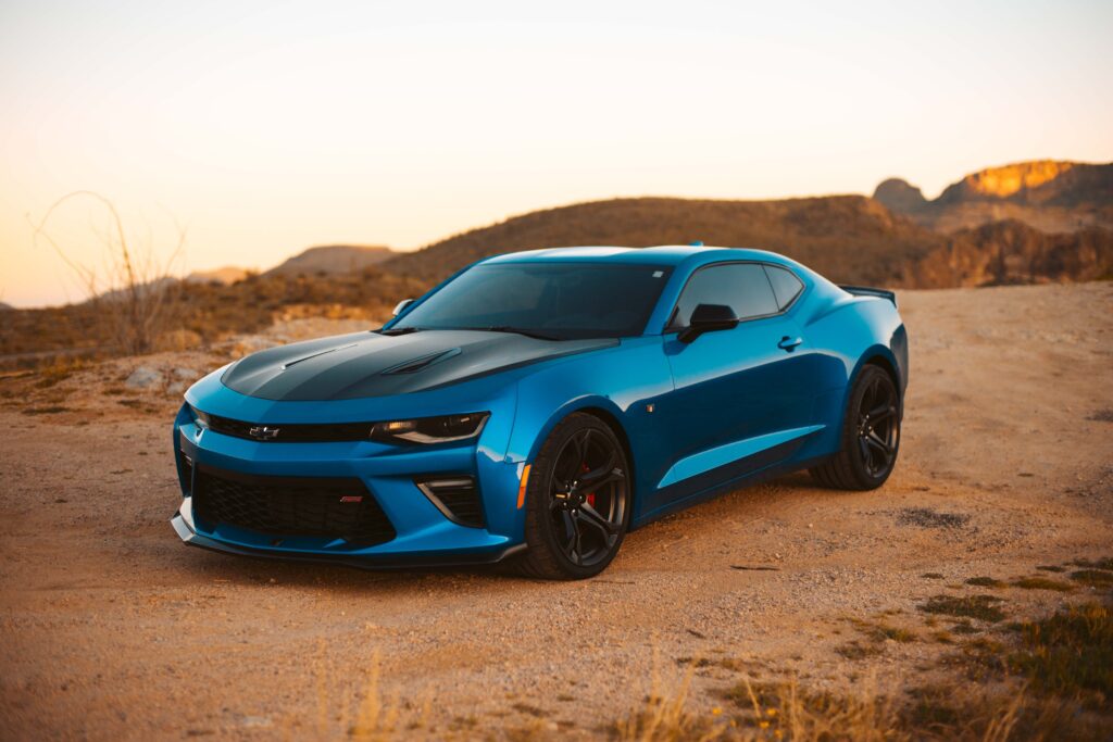 a metallic blue 2023 chevy camaro in the desert